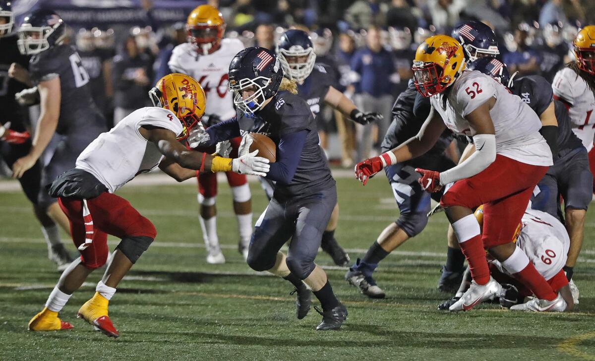 Newport Harbor running back Henry Slater fights off a tackle by Ormanie Arnold for a touchdown.