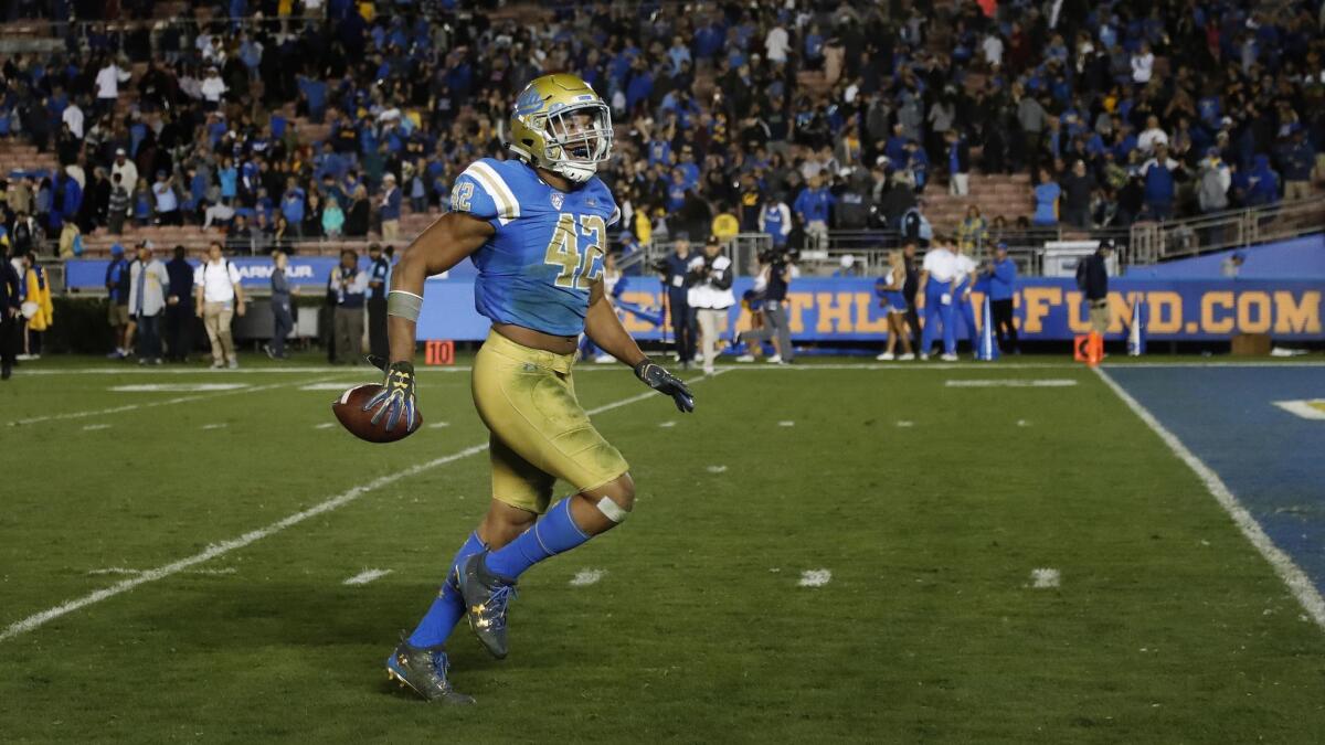 UCLA linebacker Kenny Young trots toward the end zone as he celebrates a 30-27 victory over California at the Rose Bowl on Nov. 24, 2017.