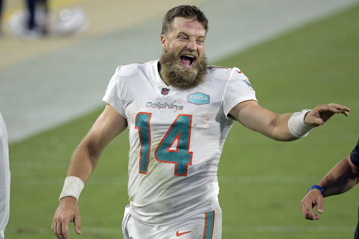 Miami Dolphins quarterback Ryan Fitzpatrick laughs with coaches on the sidelines.