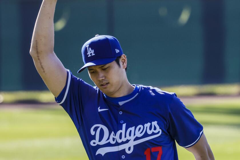 Bearing the scar of Tommy John surgery, Shohei Ohtani stretches at the LA Dodgers first official day of spring training.