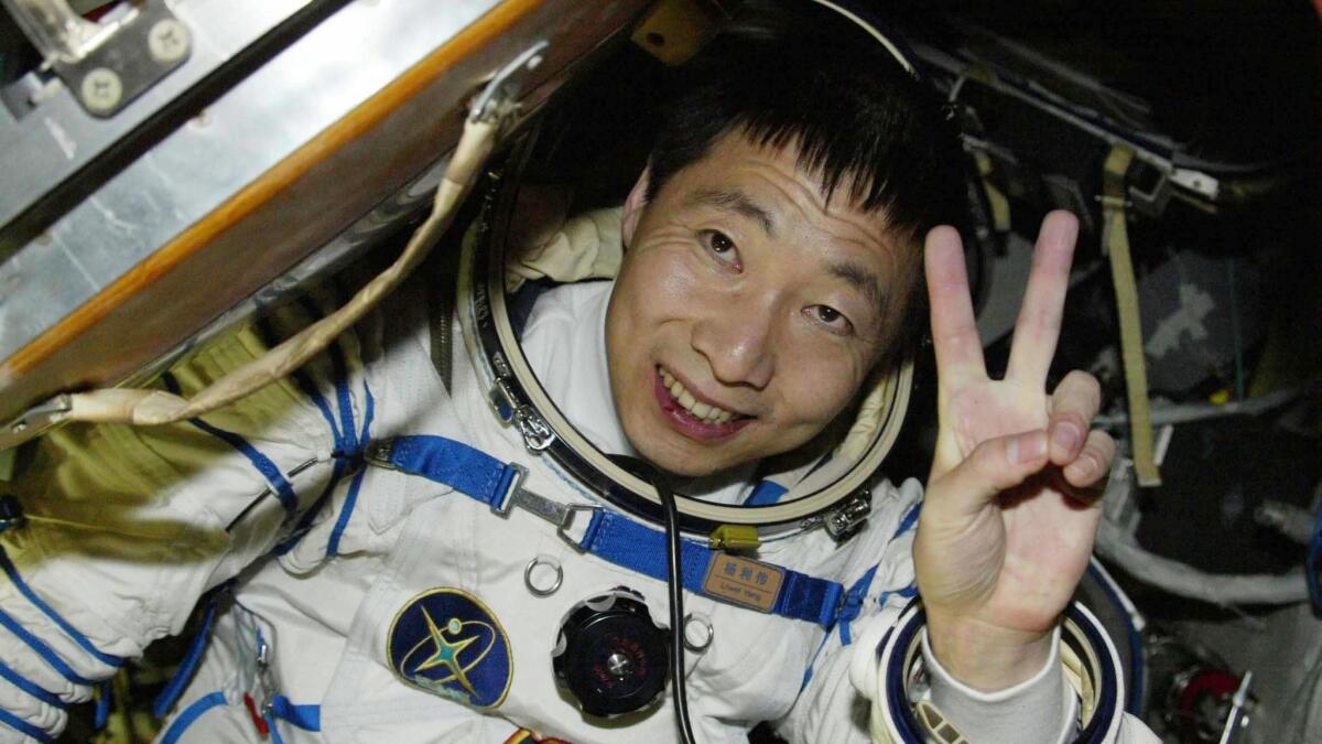 Chinese astronaut Yang Liwei waves vefore emerging from the Shenzhou V capsule in Inner Mongolia 16 October 2003. China succesfully completed its manned space flight after Yang safely returned to earth. AFP PHOTO