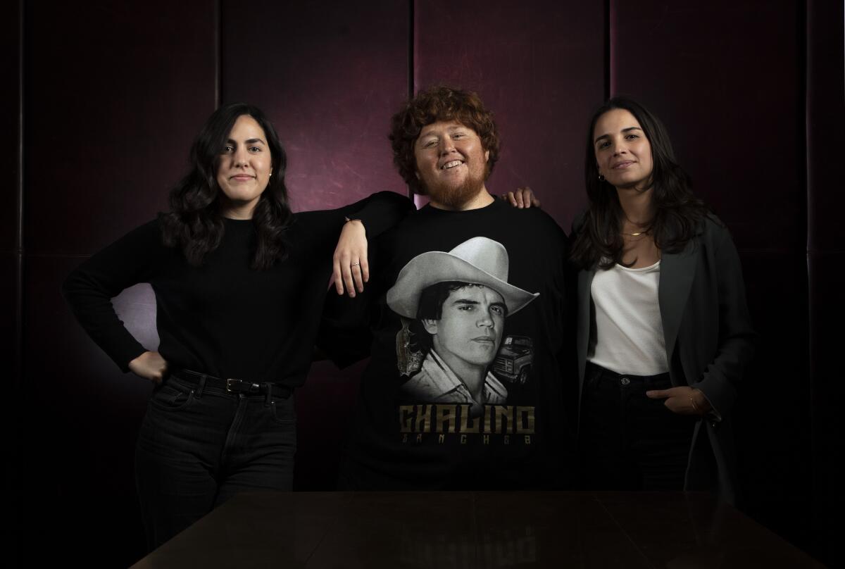 Tres personas, la del medio con una camiseta de 'Chalino' Sánchez