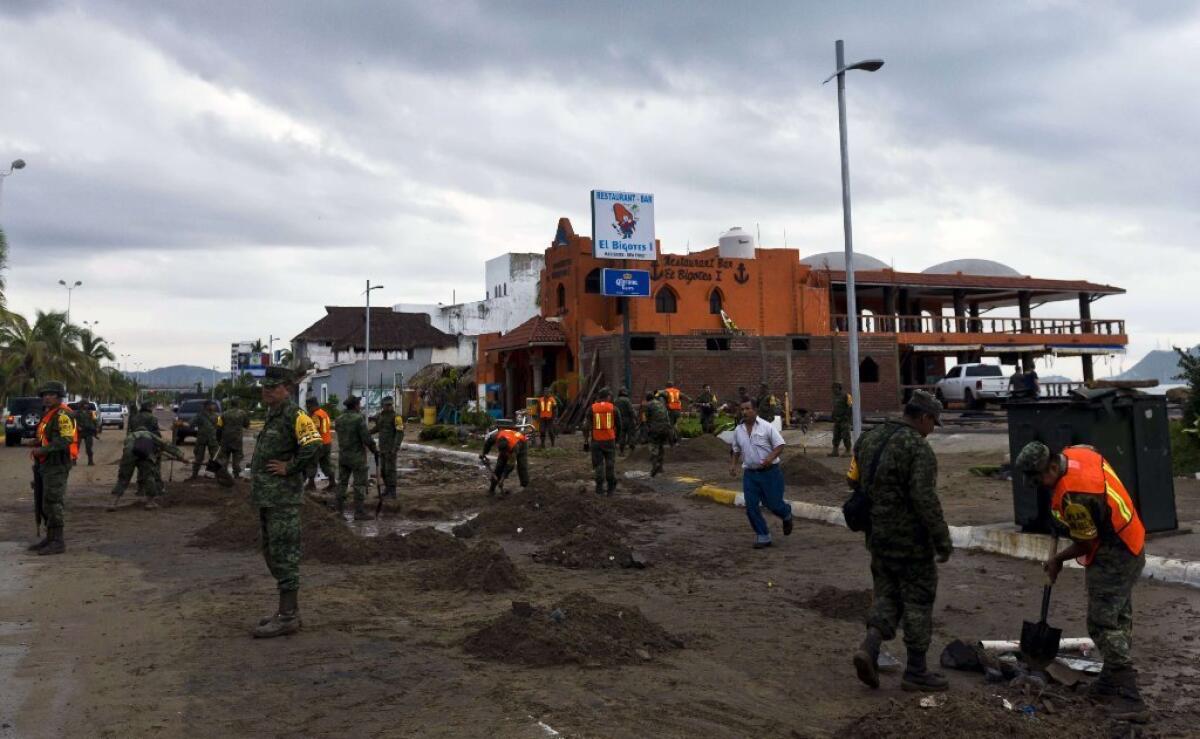 Mexican soldiers remove sand from the street in Manzanillo, in the state of Colima, after Hurricane Patricia hit the shore of neighbouring Jalisco state. Patricia weakened to a tropical storm on Saturday, dumping heavy rain that triggered flooding and landslides, but so far causing less damage than feared.