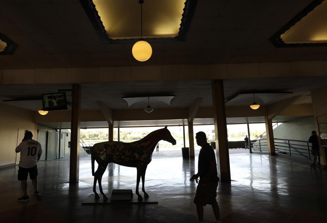 Visitors walk past a sculpture of a horse that features the artwork of Michael Massenburg.