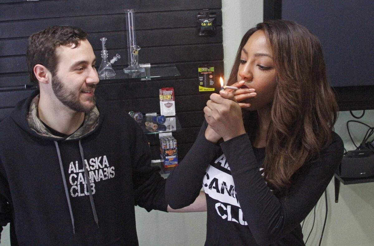 Peter Lomonaco, co-founder of the Alaska Cannabis Club, and Chief Executive Charlo Greene share a joint at their medical marijuana dispensary in Anchorage.