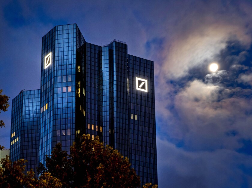 FILE — The moon shines next to the headquarters of the Deutsche Bank in Frankfurt, Germany, Oct.4, 2020. (AP Photo/Michael Probst, File)