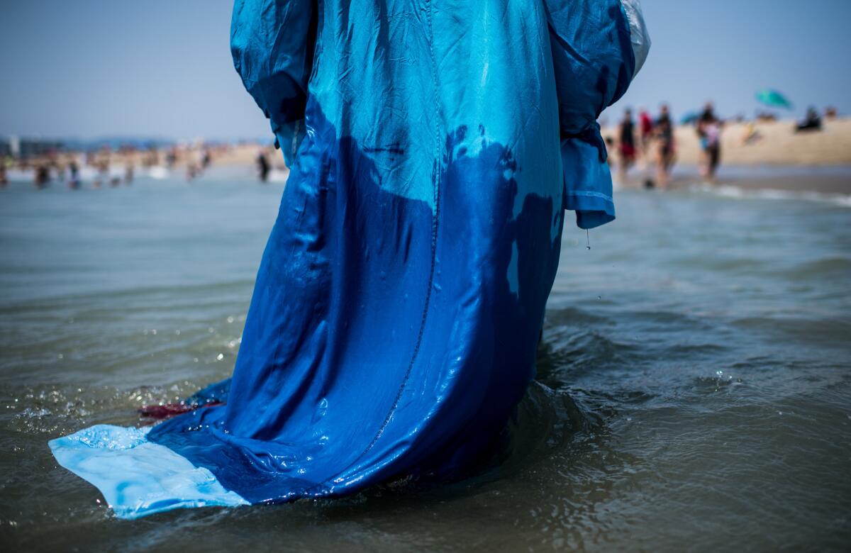 The robe of elder Keelim Brooks is soaked in ocean water before a baptism.
