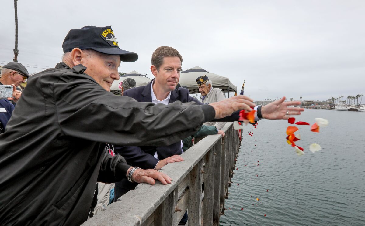 Pearl Harbor veteran George Coburn tosses flowers at a remembrance ceremony in Oceanside in 2019