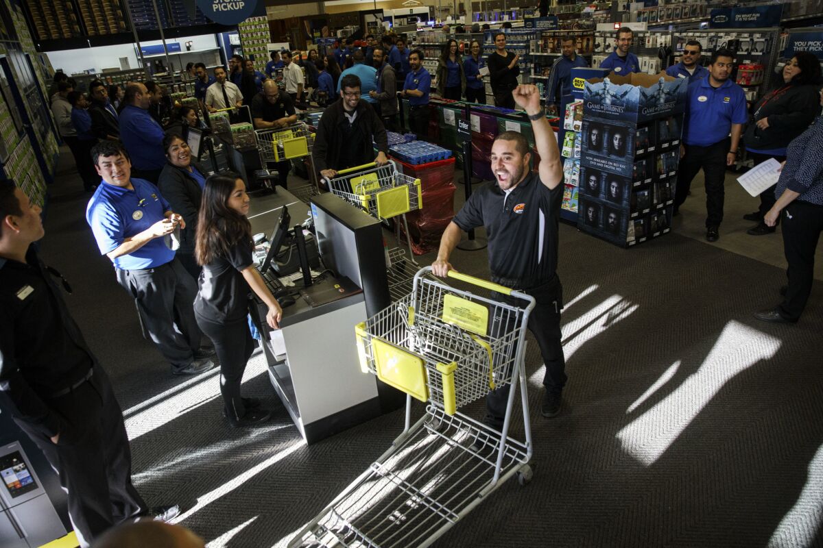 Geek Squad employee Daniel James pushes a cart while pretending to be a customer exiting the store with a purchase. It's part of the Black Friday preparations at the Best Buy in Atwater Village.