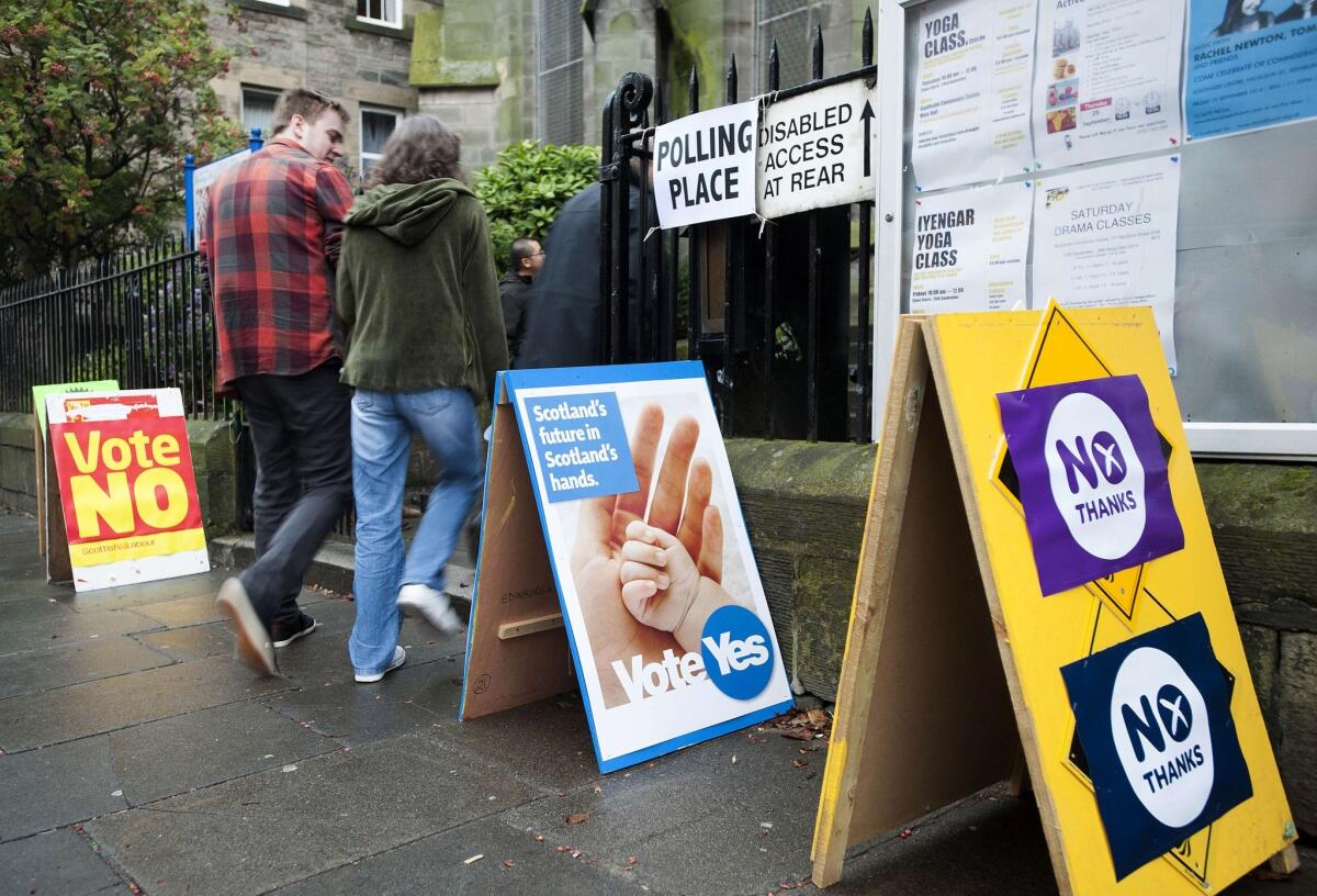 Pro-independence and pro-union signs surround a polling station in Edinburgh as voters cast ballots in Scotland's independence referendum on Sept. 18.