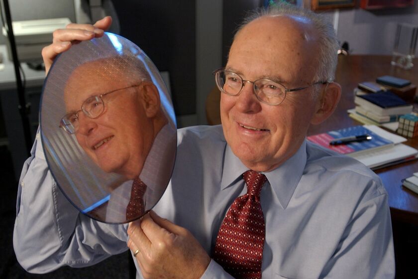 Intel Corp. co-founder Gordon Moore holds up a silicon wafer at Intel headquarters in Santa Clara, Calif., Wednesday, March 9, 2005. This is the 40th anniversary of "Moore's Law". Moore saw that the number of components on an integrated circuit had doubled every year and figured that rate would continue for a decade as transistors were made smaller. He saw that the per-component costs would fall as manufacturing improved. (AP Photo/Paul Sakuma)