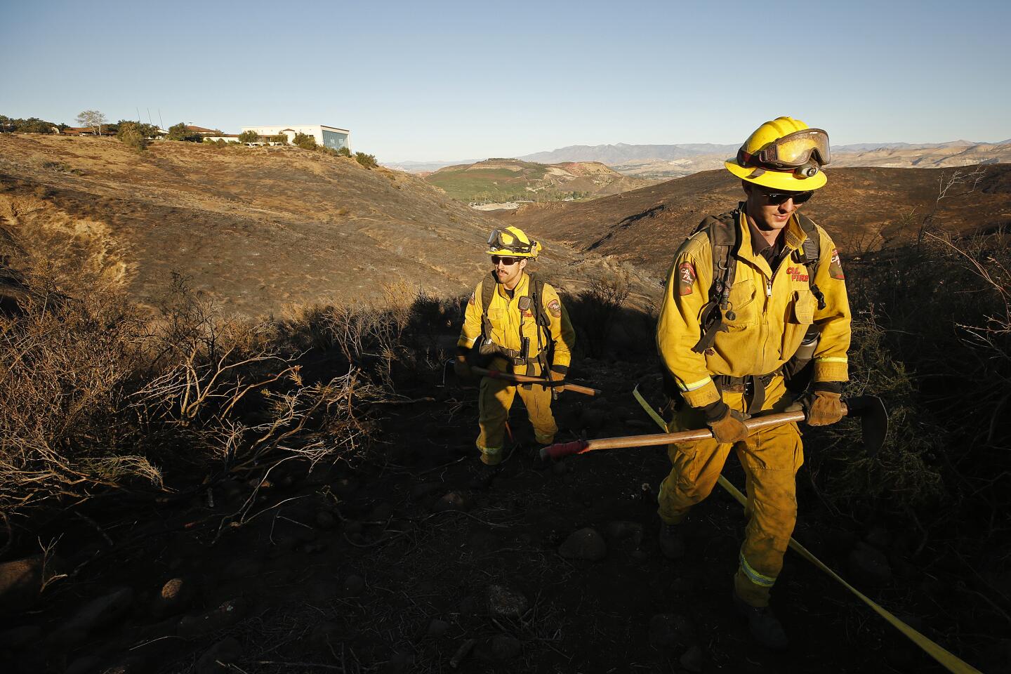 Firefighters Iann Miller, left and Austin Houck, right, from Cal Fire Tuolumne-Calaveras Unit on patrol and mop up of the Easy Fire around the Ronald Reagan Library in Simi Valley.