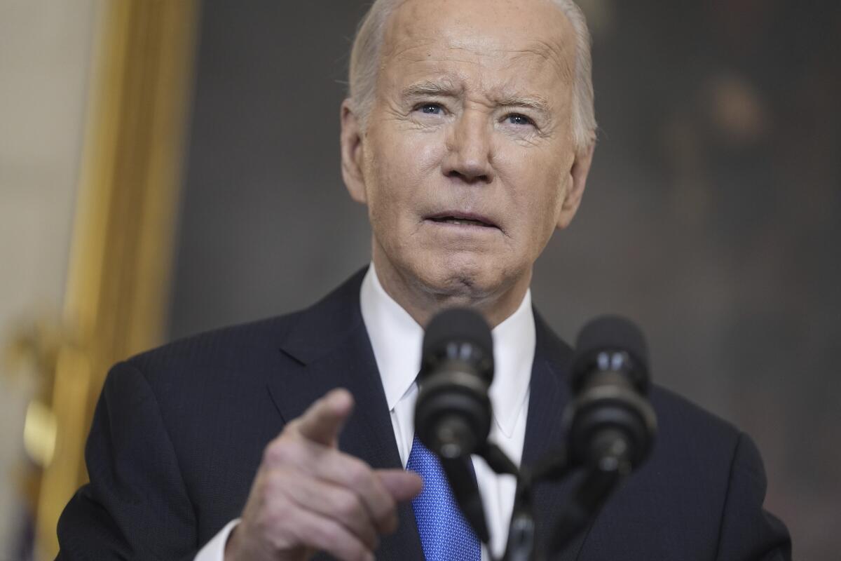 President Biden points his index finger as he speaks into a microphone