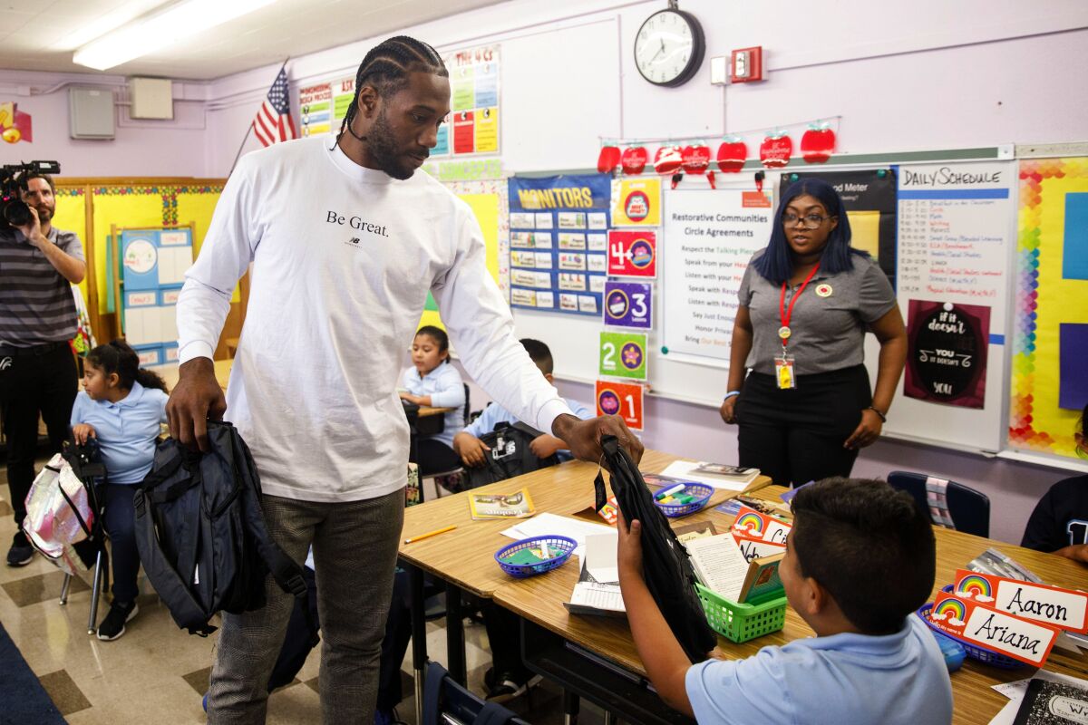Clippers star Kawhi Leonard hands out backpacks at 107th Street Elementary School in Watts. Leonard has donated a million backpacks to three Southern California school districts.