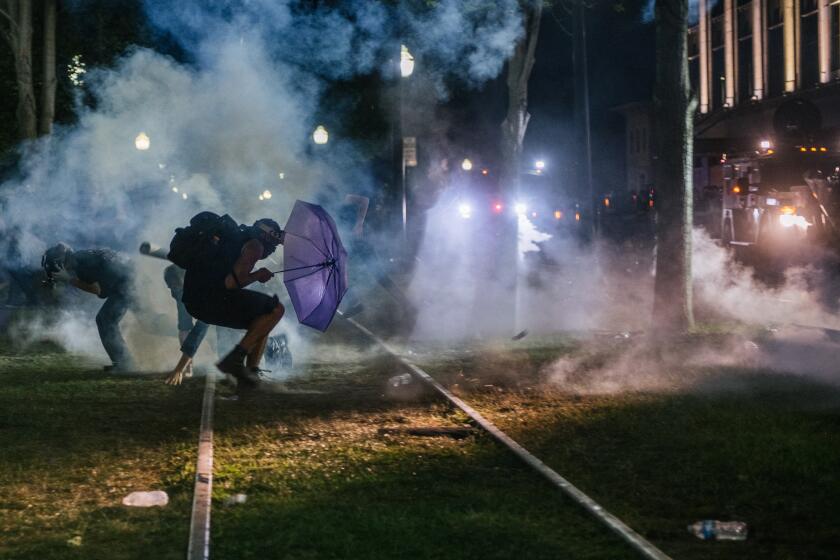 KENOSHA, WI - AUGUST 24: Demonstrators retreat from tear gas in front of the Kenosha County Courthouse on August 24, 2020 in Kenosha, Wisconsin. Additional law enforcement were deployed to protect the courthouse. Civil unrest occurred after the shooting of Jacob Blake, 29, on August 23. Blake was shot multiple times in the back by Wisconsin police officers after attempting to enter into the drivers side of a vehicle. (Photo by Brandon Bell/Getty Images)