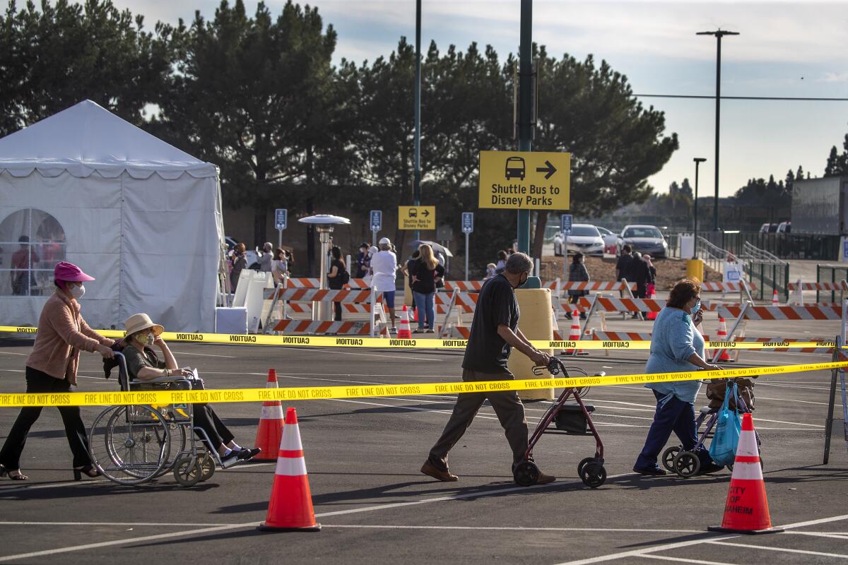 People move through the Disneyland parking lot vaccination site in Anaheim