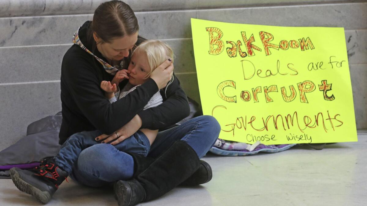 A woman and her daughter protest at the Utah Capitol in Salt Lake City on Monday. Opponents of the legislative compromise on medical marijuana complain that negotiations were held largely in private.