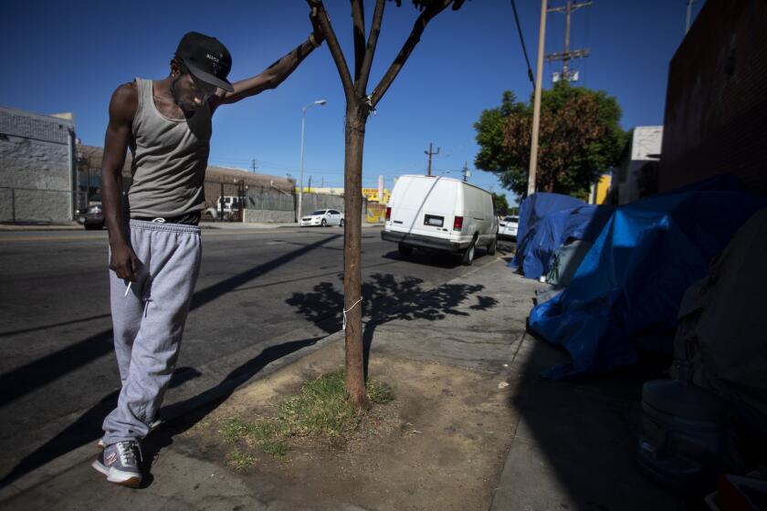 LOS ANGELES, CALIF. - OCTOBER 21: Dion Hines, 28, stands outside his tent on the sidewalk in Los Angeles, Calif. on Monday, Oct. 21, 2019. Sixteen months ago, Dion Hines had moved into a new apartments with bathtubs and dishwashers, heating and air conditioning. Dion relinquished his new unit and has found himself back to his old neighborhood. (Francine Orr / Los Angeles Times)