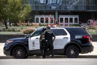 LOS ANGELES, CA - JUNE 21, 2021: A member of the LAPD gets into his patrol car parked in front of LAPD Headquarters on 1st St. in downtown Los Angeles. (Mel Melcon / Los Angeles Times)