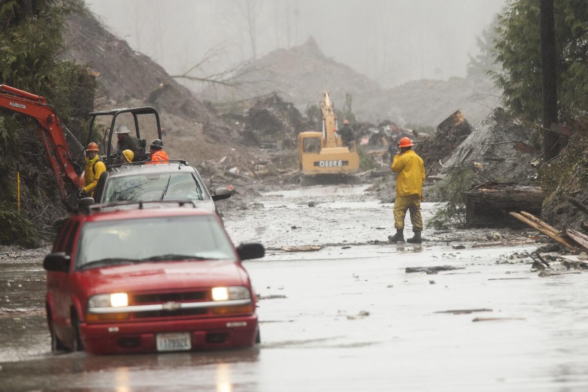 A car enters floodwater at the mudslide in Oso, Wash.