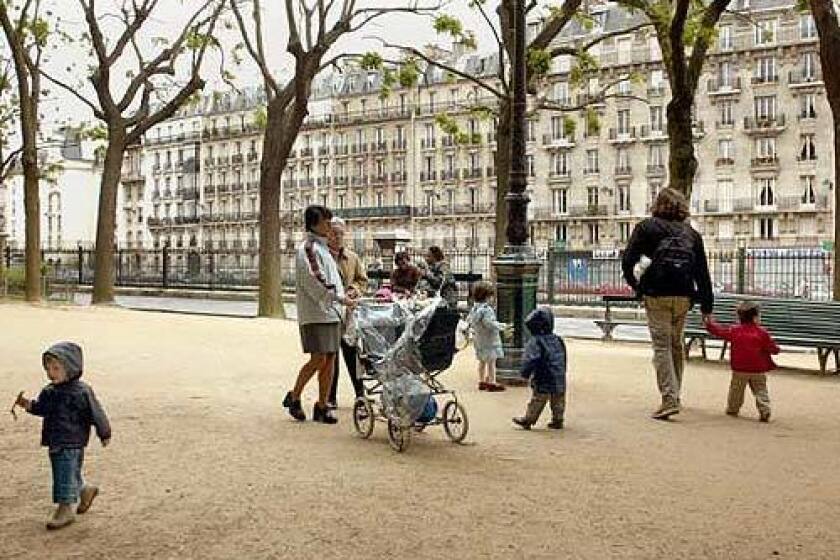 Paris can be family friendly. Parents and children amble in the Square des Batignolles.