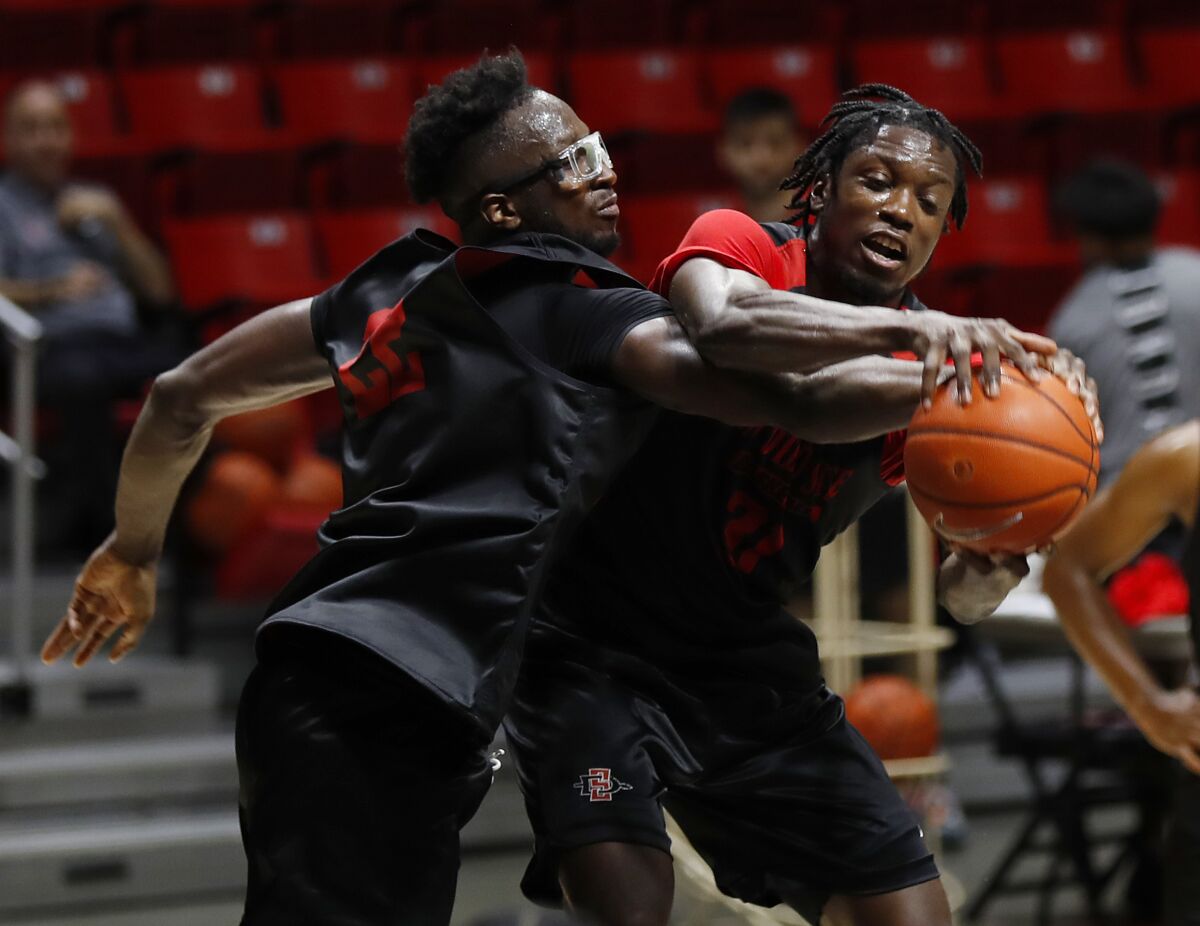 Mali's Tahirou Diabate (left) and Ghana's Nathan Mensah fight for a rebound during an Aztecs practice.