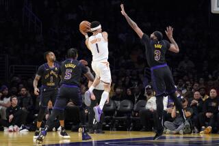 Phoenix guard Devin Booker tries to pass as Lakers D'Angelo Russell, Cam Reddish and Anthony Davis defend.