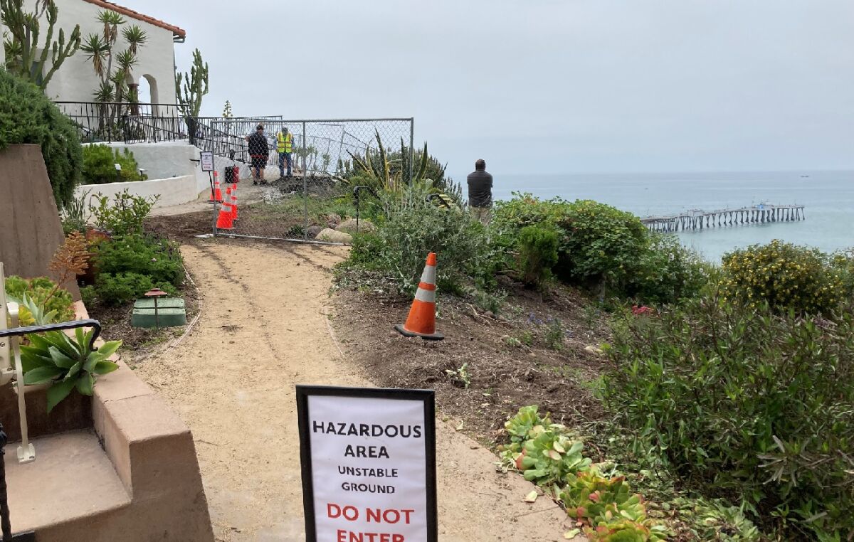 Local officials examine a landslide Friday at Casa Romantica in San Clemente