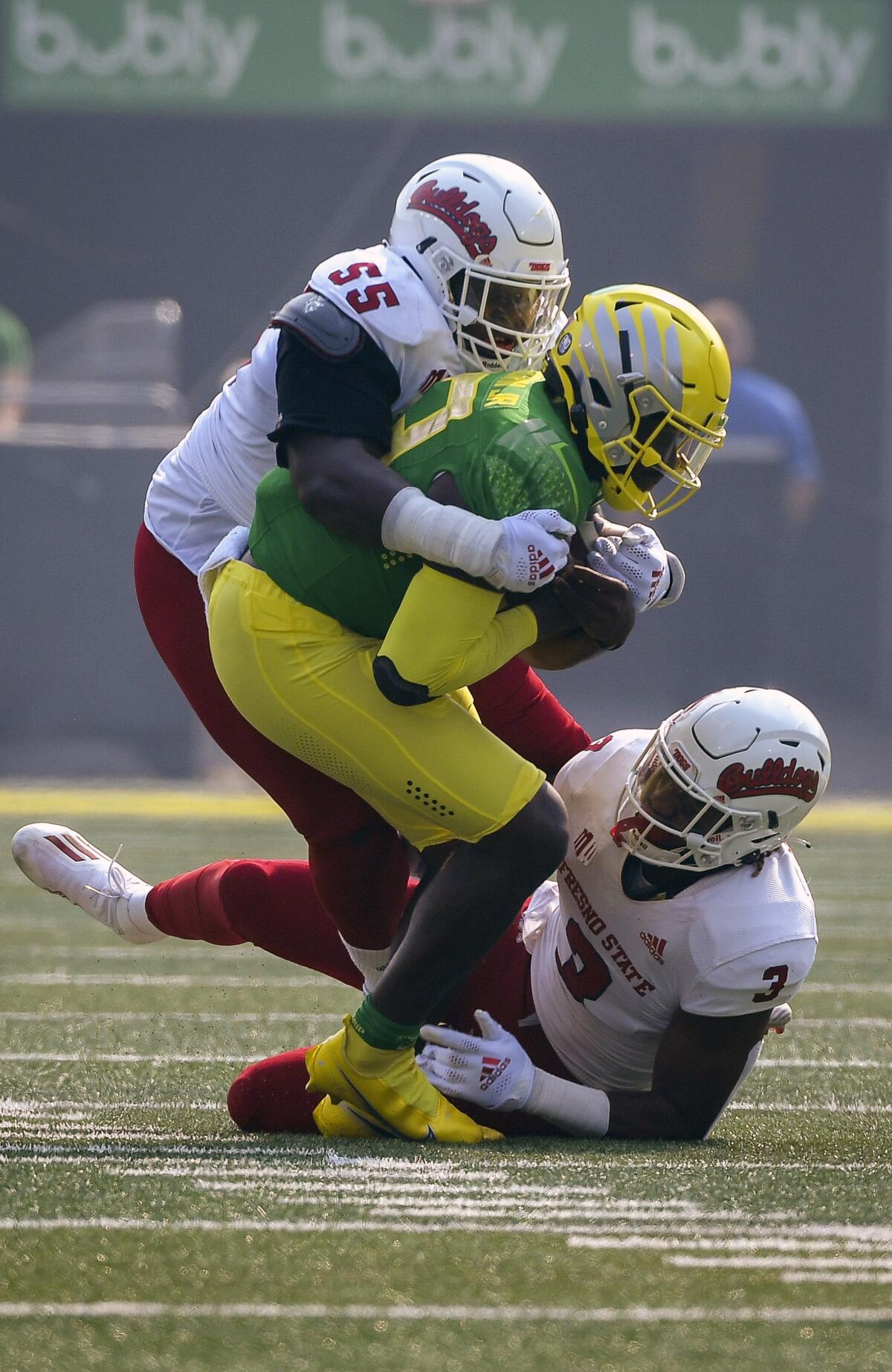 Oregon quarterback Anthony Brown (13) is wrapped up by Fresno State tackle Leonard Payne (55) and defensive end Aaron Mosby (3) during the first quarter of an NCAA college football game, Saturday, Sept. 4, 2021, in Eugene, Ore. (AP Photo/Andy Nelson)