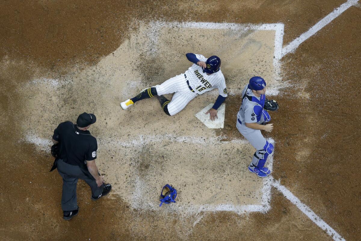 Milwaukee's Kolten Wong scores from third behind Dodgers catcher Will Smith during the eighth inning.
