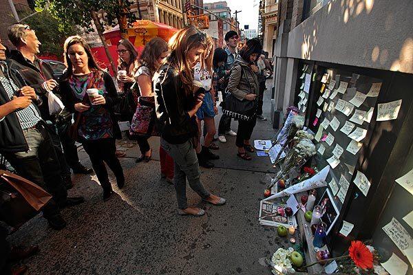 People gather at the Apple store in New York City's SoHo neighborhood, leaving messages and flowers for Steve Jobs, who died on Wednesday.