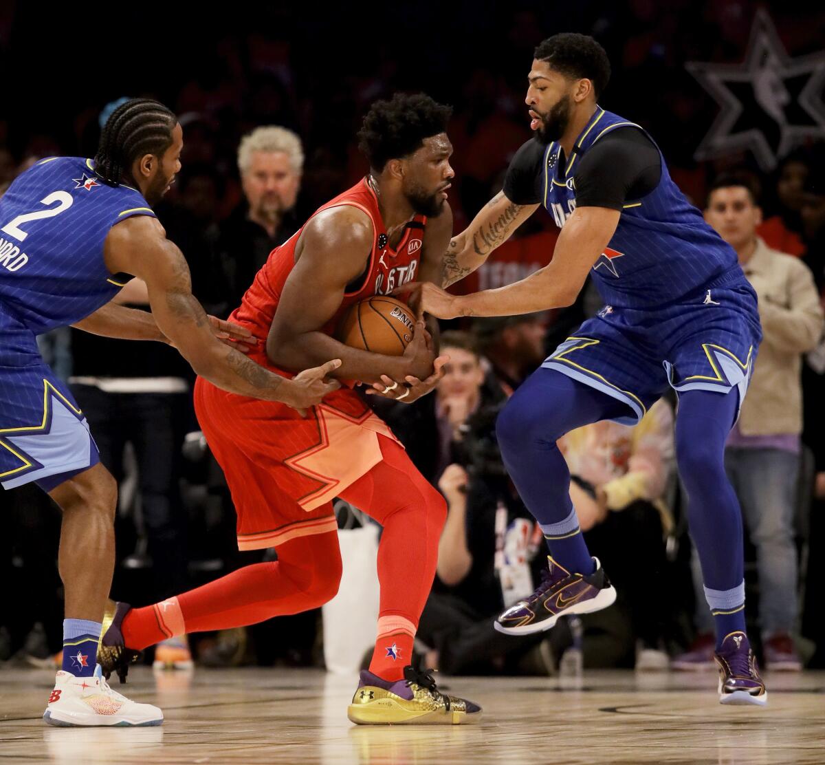 Clippers forward Kawhi Leonard and Lakers forward Anthony Davis trap 76ers center Joel Embiid.
