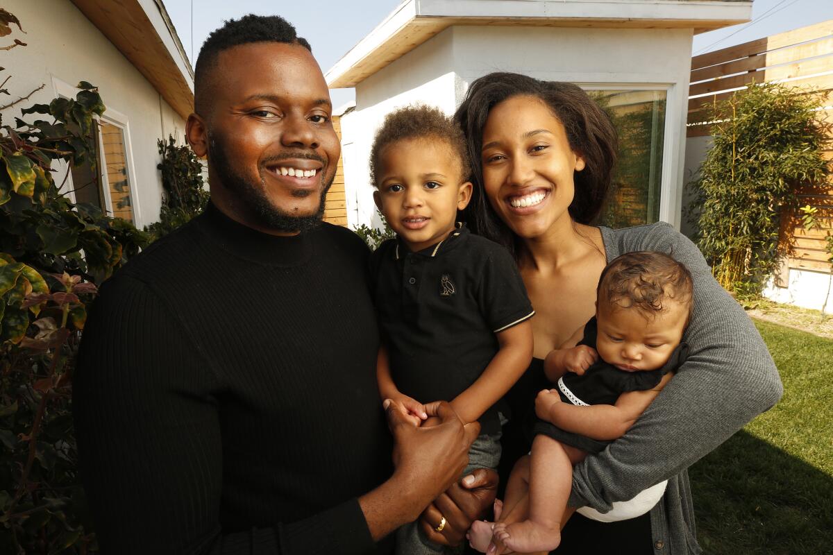Michael Tubbs smiles at home with his wife and their two little boys.