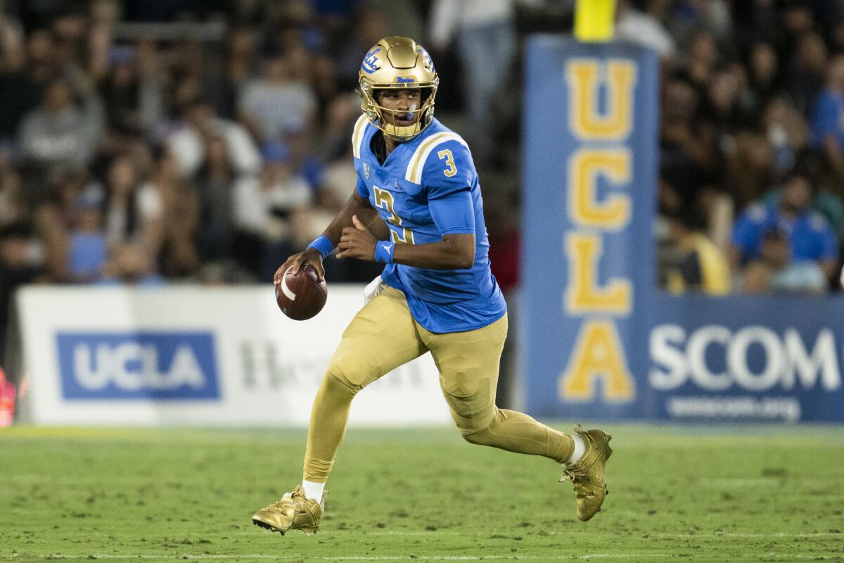 UCLA quarterback Dante Moore runs with the ball.