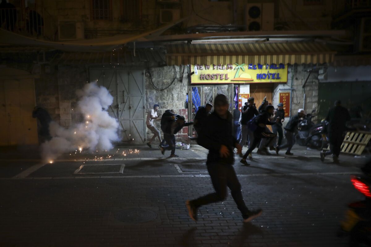 Palestinians running from stun grenades