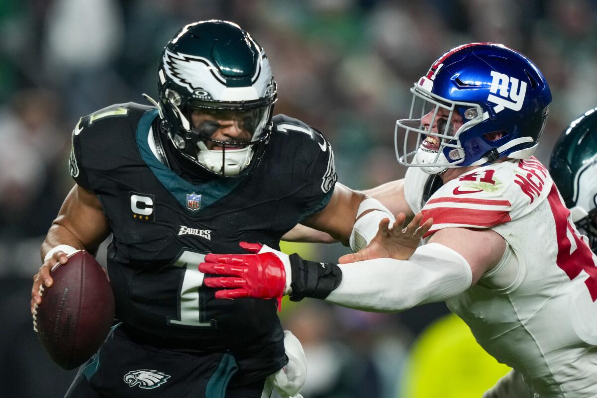 Philadelphia Eagles quarterback Jalen Hurts pushes off New York Giants linebacker Micah McFadden during the first half.