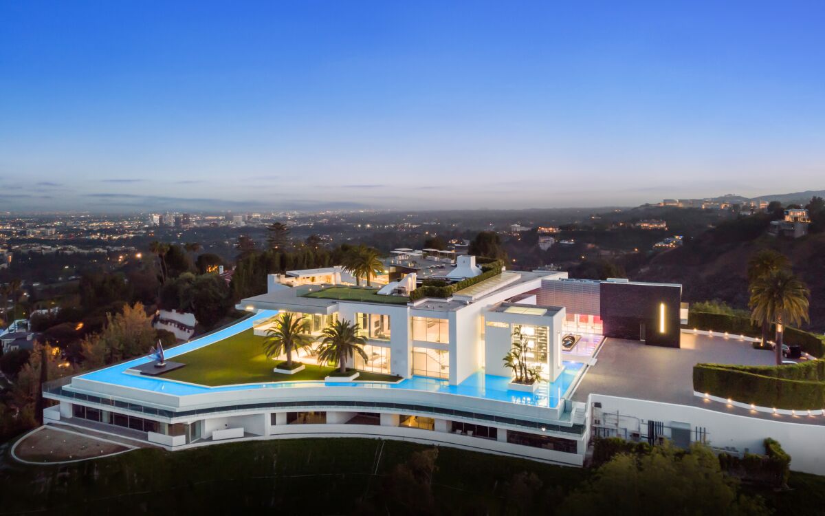 The mega-mansion known as ‘The One’ has a modern look and overlooks a hill at the cityscape in the distance.