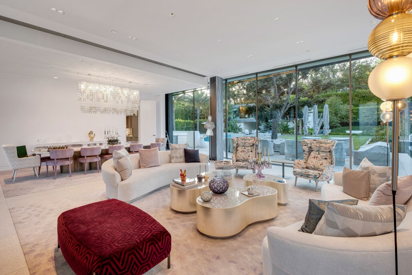 The house has open-plan living spaces and glass walls.