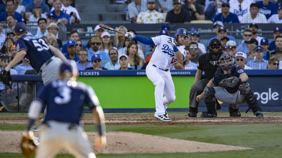 Dodgers first baseman Max Muncy hits an RBI single off Milwaukee Brewers relief pitcher Brandon Woodruff in the sixth inning of the NLCS.