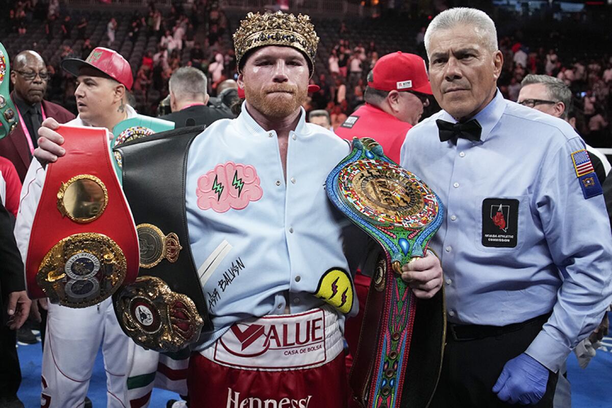 Canelo Alvarez celebrates with his title belts in the ring after defeating Gennady Golovkin.
