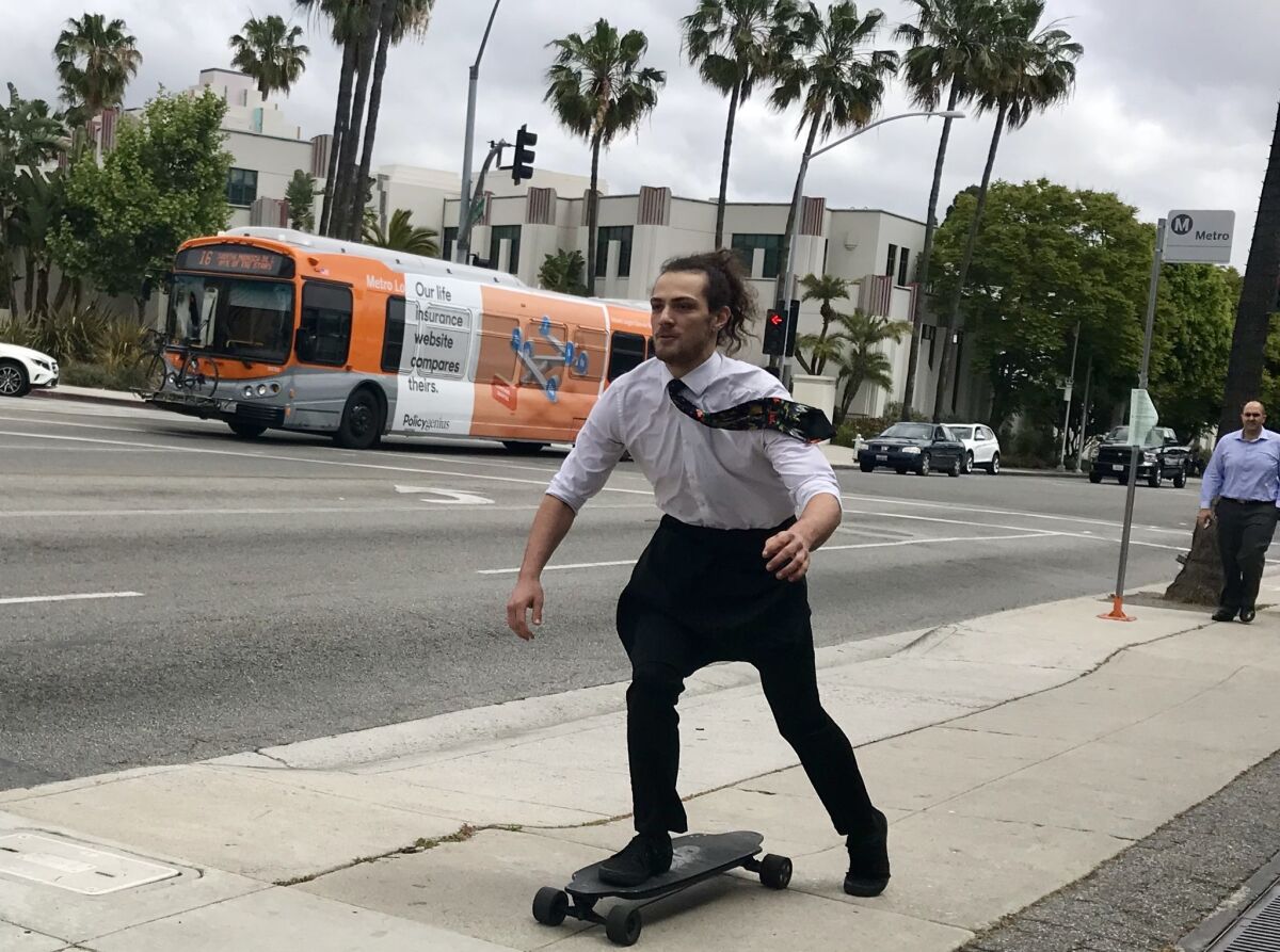 Dante Ayala, 22, rides a skateboard to his job as a waiter in Beverly Hills. He said he’s all in on Mayor Eric Garcetti’s vision of an L.A. future with driverless electric cars.