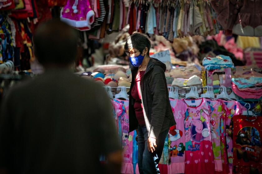 LOS ANGELES, CA - SEPTEMBER 24: A woman shops at Dynasty Center in Chinatown's swap meet district on Friday, Sept. 24, 2021 in Los Angeles, CA. (Jason Armond / Los Angeles Times)