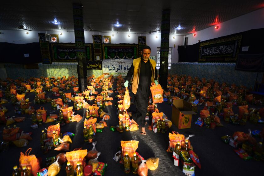 A man sorts donations for families in need in the central Iraqi holy city of Najaf on March 25, 2020 amid the COVID-19 coronavirus pandemic. (Photo by Haidar HAMDANI / AFP) (Photo by HAIDAR HAMDANI/AFP via Getty Images)