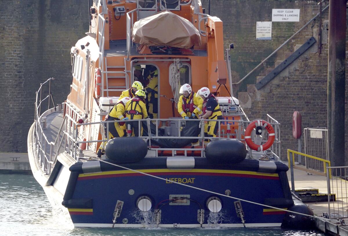 Rescuers placing a body bag on a boat