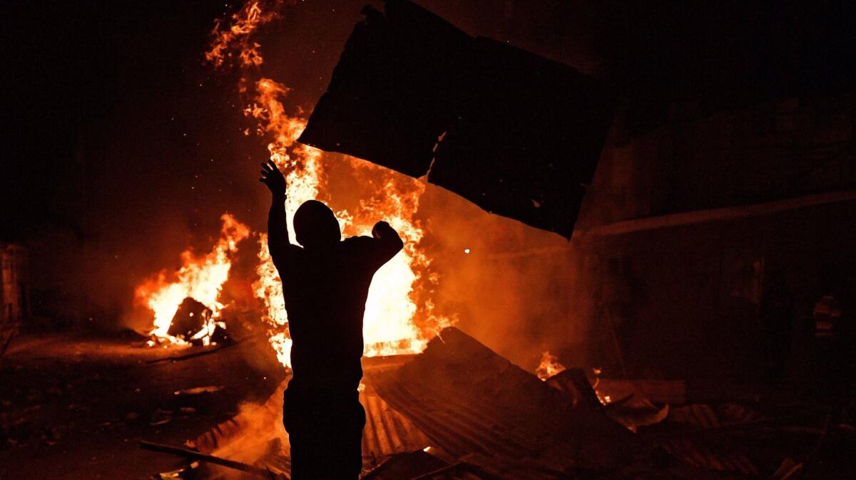 Protesters loot and burn in the Nairobi slum of Kibera after Kenya's President Uhuru Kenyatta was declared the winner of a hard-fought election.