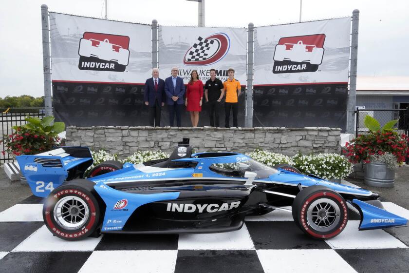 Roger Penske, from left, Chairman of Penske Corporation, Wisconsin Gov. Tony Evers, Shari Black, State Fair Park CEO, 6-time IndyCar Champion Scott Dixon, second-year NTT IndyCar Series driver David Malukas stand in Victory Circle before a press conference announcing the return of IndyCar auto racing at Milwaukee Mile, Monday, Sept. 25, 2023, in West Allis on. IndyCar announced its schedule Monday morning, including a doubleheader on Labor Day weekend that gives the 120-year-old track at State Fair Park new life yet again. (Mike De Sisti/Milwaukee Journal-Sentinel via AP)