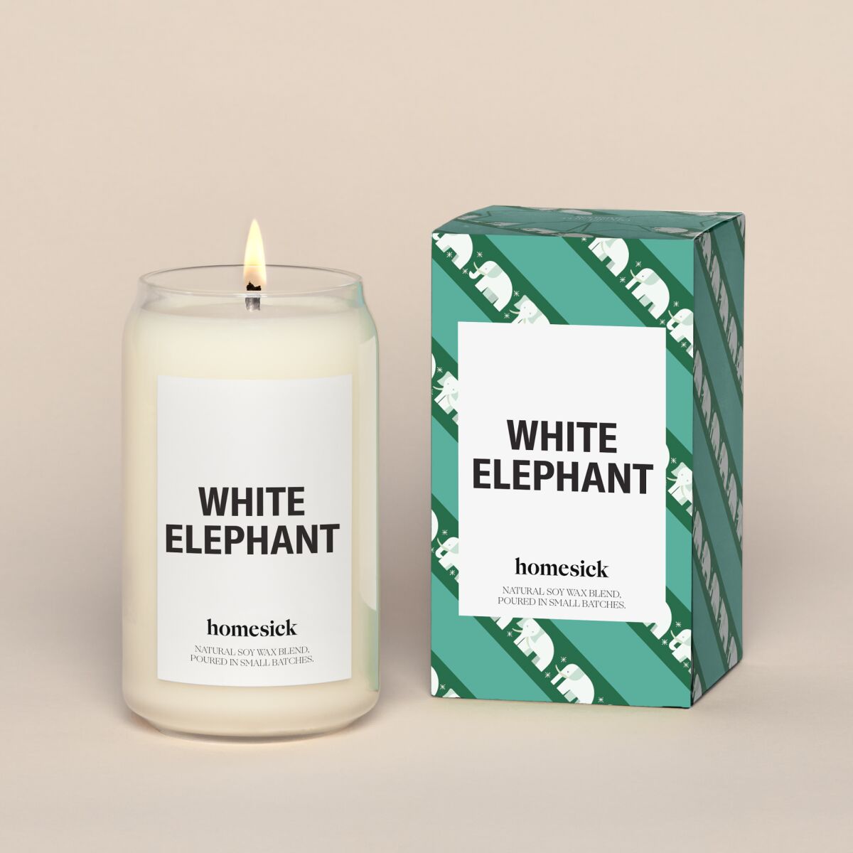 Une bougie dans un bocal en verre à côté d'une boîte à motifs vert et blanc. L'étiquette sur les deux lectures "Éléphant blanc."