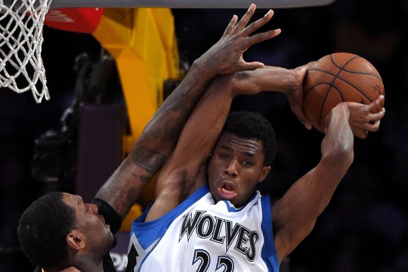 Timberwolves forward Andrew Wiggins tries to pass while under pressure from Lakers forward Tarik Black in the first half Friday night.