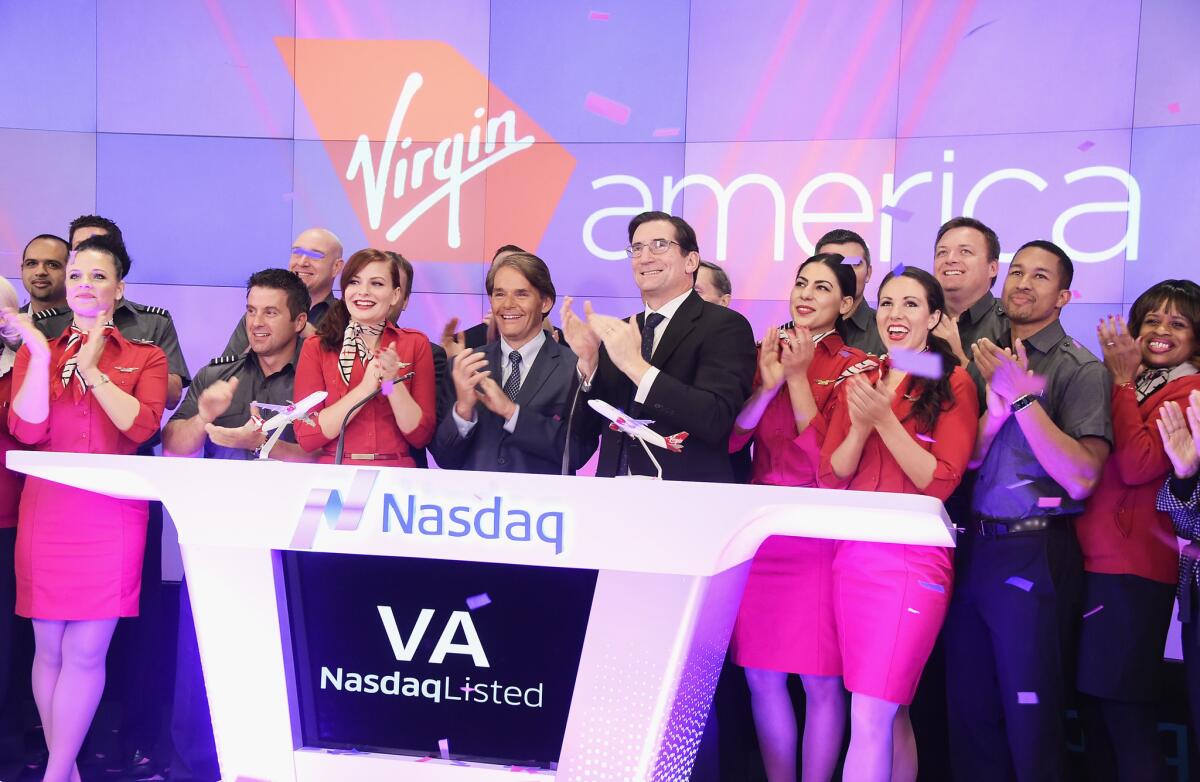 Virgin America CEO David Cush, center, and Nasdaq CEO Robert Greifeld, right, ring the exchange's opening bell in New York on Nov. 14.