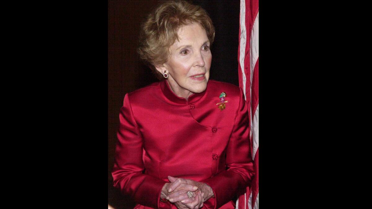 In 2000, former First Lady Nancy Reagan listens as a reporter asks about the condition of her husband, former President Ronald Reagan.